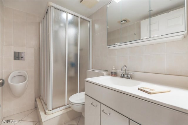 bathroom featuring tile patterned flooring, vanity, a shower with shower door, and tile walls