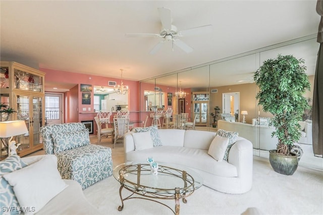 living room featuring ceiling fan with notable chandelier