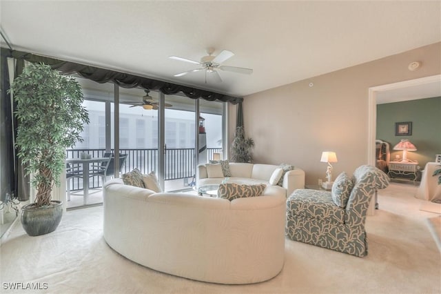 carpeted living room with a wall of windows and ceiling fan