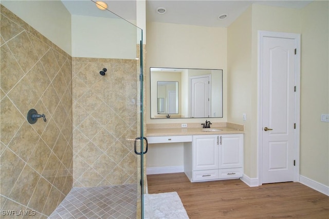 bathroom with hardwood / wood-style floors, vanity, and walk in shower