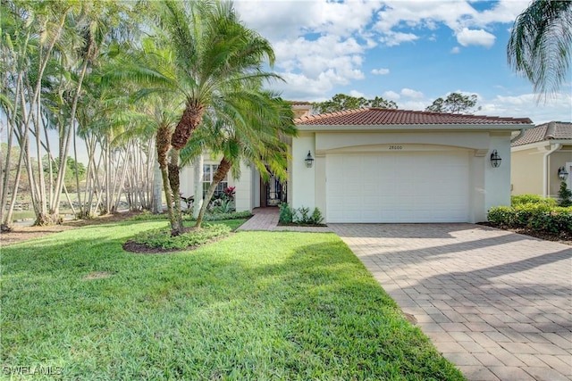 mediterranean / spanish-style house featuring a garage and a front lawn