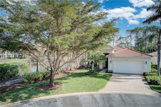 view of front of house with a water view, a front yard, and a garage