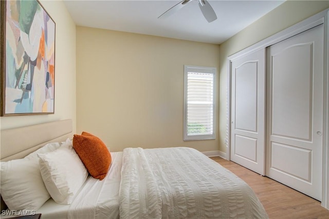 bedroom featuring ceiling fan, light wood-type flooring, and a closet