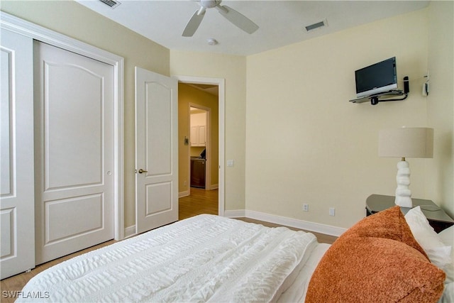 bedroom featuring ceiling fan, light hardwood / wood-style flooring, and a closet