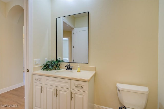 bathroom featuring vanity, wood-type flooring, and toilet