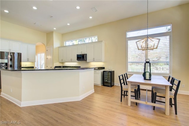 kitchen with white cabinetry, beverage cooler, stainless steel fridge with ice dispenser, light hardwood / wood-style flooring, and decorative light fixtures