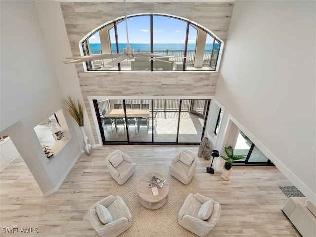 living room featuring a water view and a high ceiling