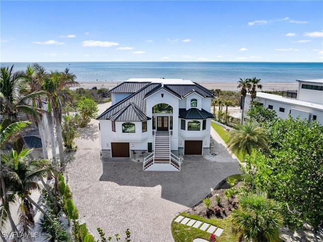 exterior space featuring a garage, a beach view, and a water view