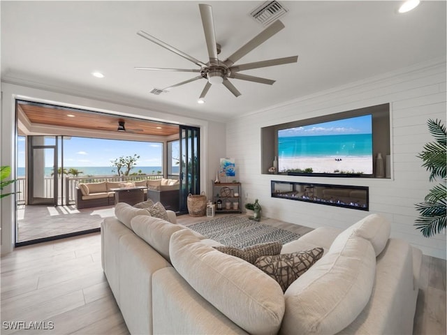 living room featuring ceiling fan and ornamental molding