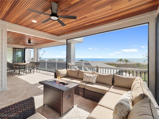 view of patio featuring a water view and an outdoor living space with a fire pit