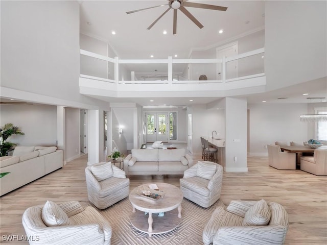 living room with a towering ceiling and light hardwood / wood-style floors