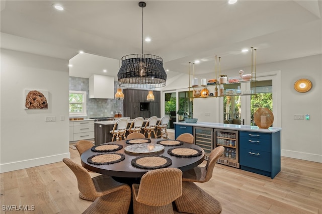 dining space with recessed lighting, beverage cooler, baseboards, and light wood finished floors