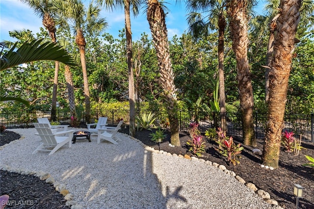 view of yard with a fire pit, a patio, and fence