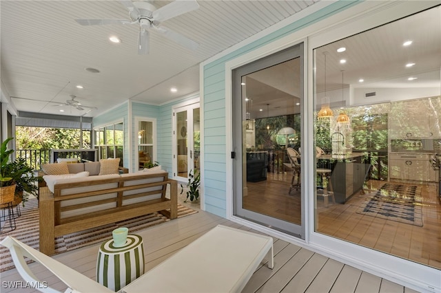 sunroom with ceiling fan, visible vents, and a sink