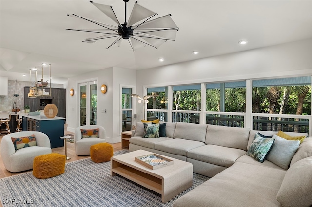 living room featuring a notable chandelier, plenty of natural light, wood finished floors, and recessed lighting