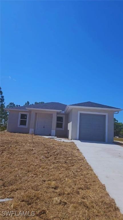 3019 32nd St W, Lehigh Acres, FL 33971 - ranch-style house with driveway, an attached garage, and stucco siding