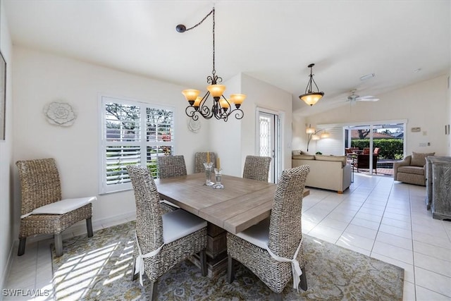 tiled dining room featuring lofted ceiling and ceiling fan with notable chandelier