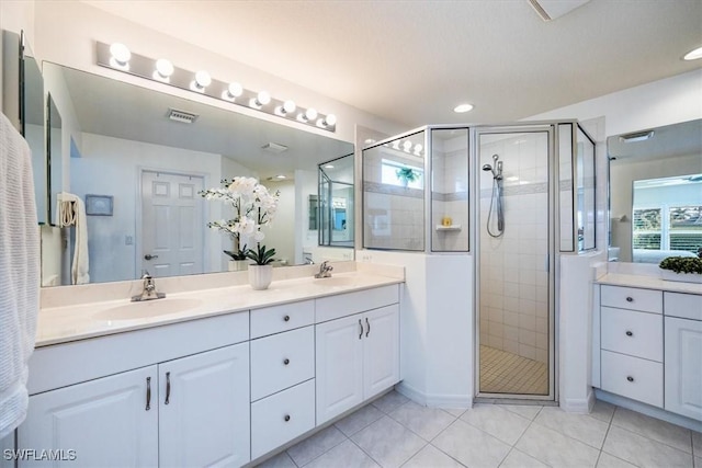 bathroom featuring tile patterned floors, vanity, and a shower with shower door