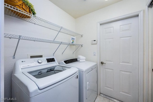 laundry area featuring washer and clothes dryer and light tile patterned floors