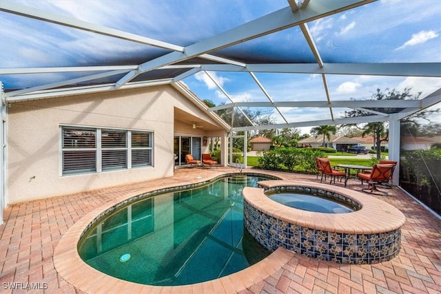 view of pool featuring an in ground hot tub, glass enclosure, and a patio area