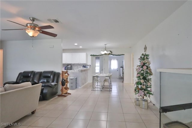 tiled living room featuring ceiling fan with notable chandelier