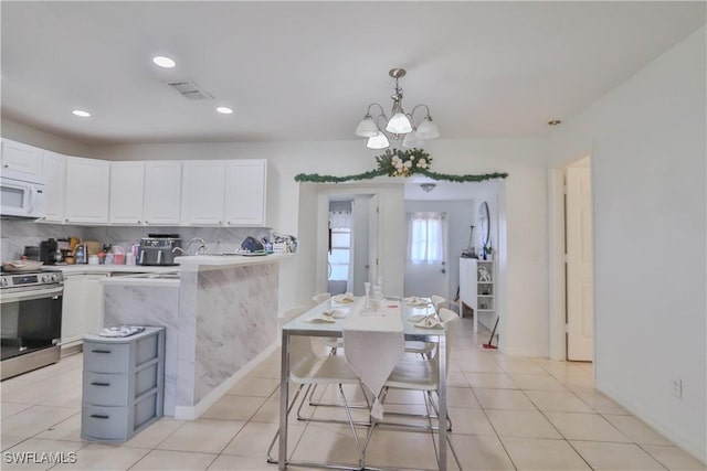 kitchen featuring pendant lighting, white cabinetry, stainless steel range, and tasteful backsplash