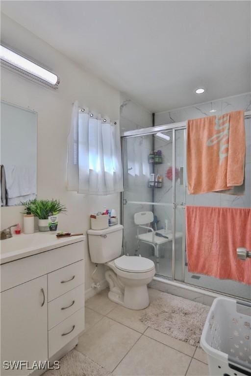 bathroom featuring tile patterned flooring, vanity, toilet, and walk in shower