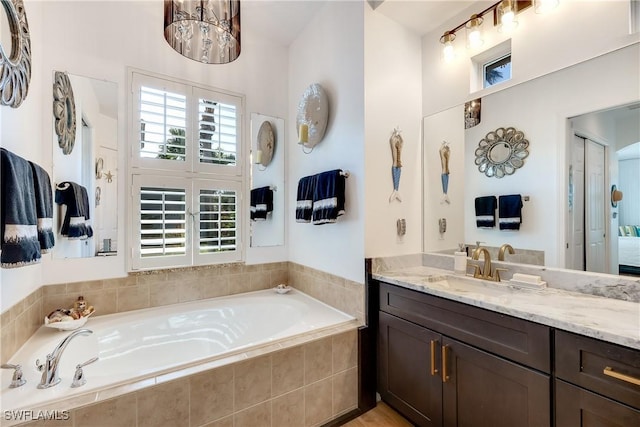 bathroom with vanity and a relaxing tiled tub