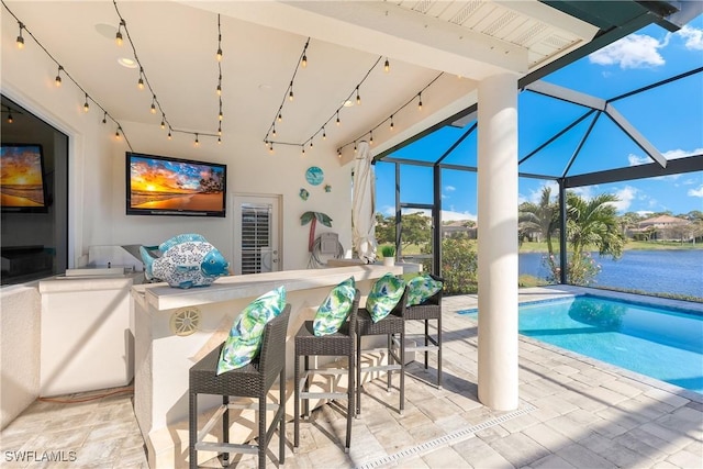 view of swimming pool with a bar, a patio, a water view, and glass enclosure