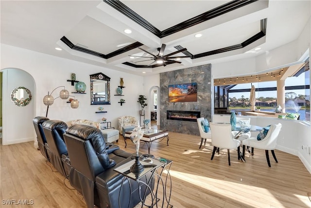 living room featuring ornamental molding, coffered ceiling, ceiling fan, light hardwood / wood-style flooring, and a fireplace