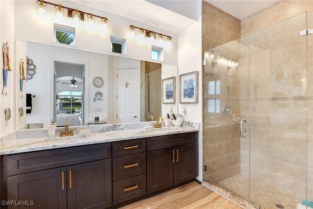 bathroom featuring ceiling fan, a shower with door, vanity, and hardwood / wood-style floors