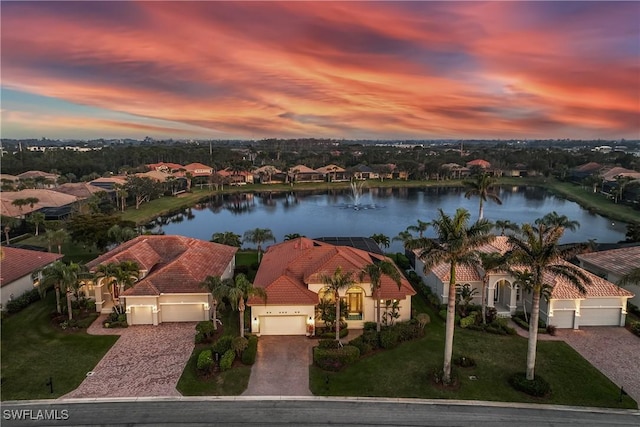 aerial view at dusk featuring a water view