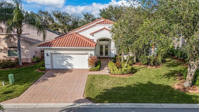 mediterranean / spanish house featuring a front yard, a garage, and french doors