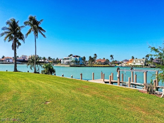 view of dock with a yard and a water view