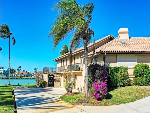 view of front of home featuring a balcony, a water view, and a garage