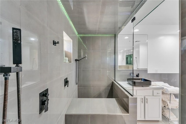 bathroom featuring tiled shower and vanity