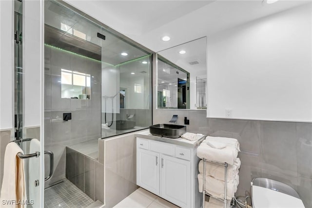 bathroom featuring tile patterned floors, tile walls, vanity, and an enclosed shower