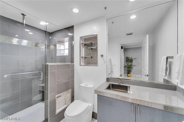 bathroom featuring vanity, toilet, and an enclosed shower