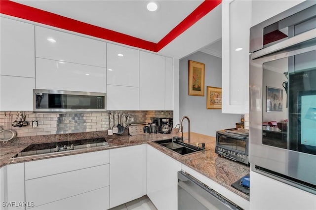 kitchen featuring sink, white cabinets, stainless steel appliances, and stone countertops