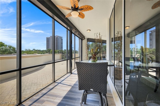 sunroom / solarium featuring ceiling fan