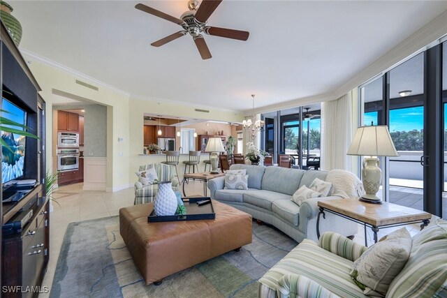 living room featuring ceiling fan with notable chandelier, light tile patterned floors, and crown molding