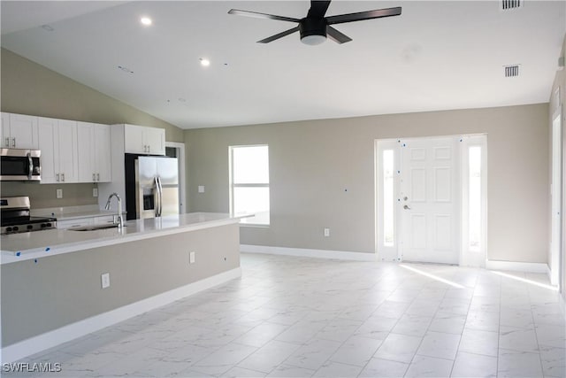 kitchen with sink, ceiling fan, appliances with stainless steel finishes, high vaulted ceiling, and white cabinets