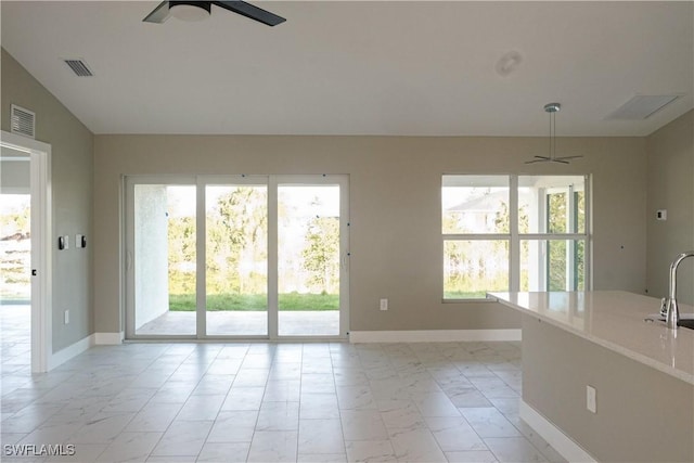 unfurnished living room with sink, plenty of natural light, ceiling fan, and vaulted ceiling