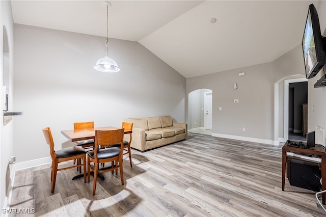 dining space with light hardwood / wood-style flooring and lofted ceiling