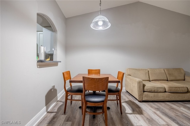 dining room featuring hardwood / wood-style flooring and lofted ceiling