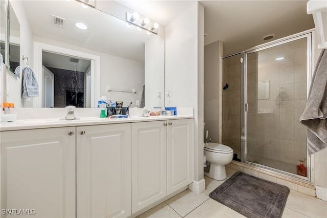 bathroom featuring tile patterned flooring, vanity, toilet, and a shower with door