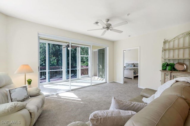 carpeted living room featuring baseboards and a ceiling fan