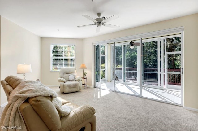 living area featuring a ceiling fan, carpet, and baseboards