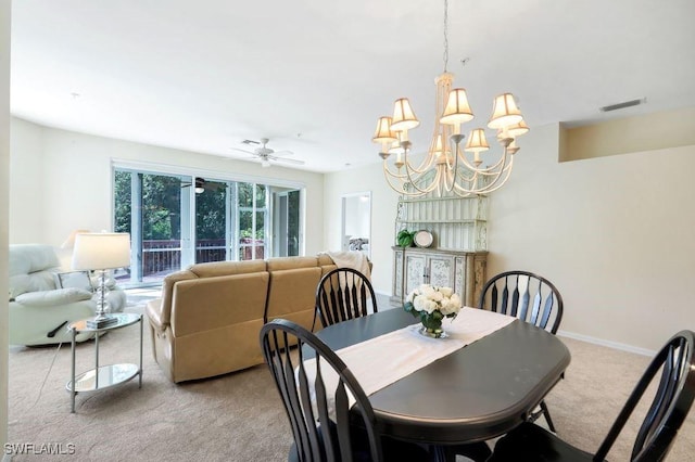 dining space featuring ceiling fan with notable chandelier, visible vents, baseboards, and light carpet