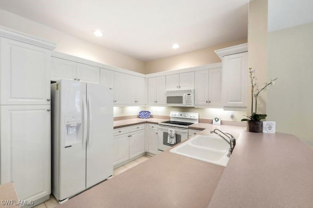 kitchen featuring white cabinets, white appliances, and a sink